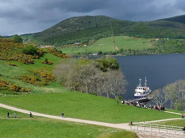 Un bateau de tourisme manœuvrant sur le Loch Ness près du château d’Urquhart